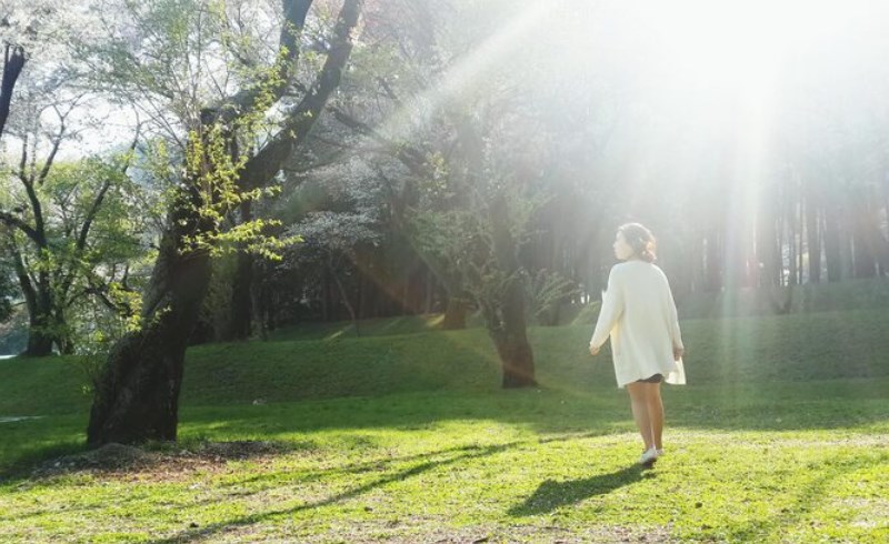 자연 속에서 산책하며 땅의 기운(토기운)을 받는 사람의 모습
