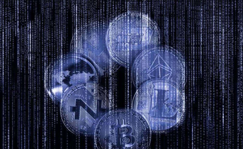 다양한 암호화폐 로고가 그려진 동전들이 분산되어 있는 모습