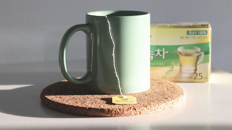 사주 화(火) 과다 성격 급할 때 마시는 개운 차 추천: 마음의 불길을 잠재우는 비법 4 찻잎과 함께 놓인 녹차 한 잔