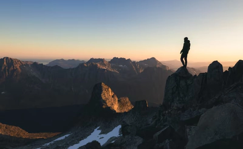산 정상에서 아래를 내려다보는 성공한 사람의 뒷모습
