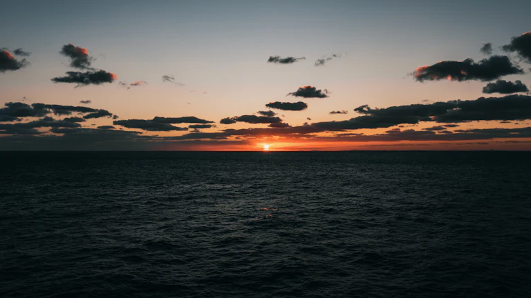 잔잔한 바다 위로 떠오르는 태양