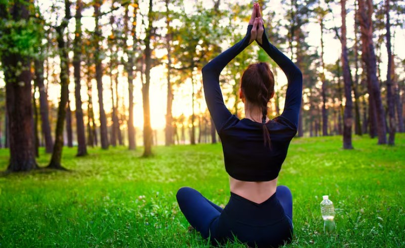 숲속에서 요가를 하는 여성의 모습