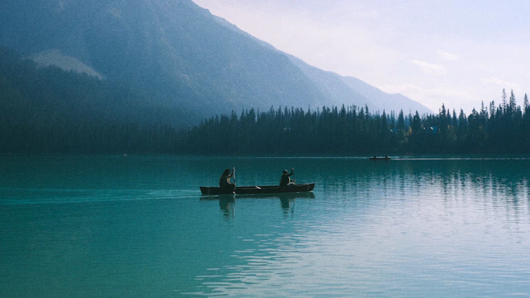 잔잔한 호숫가에서 명상하는 사람