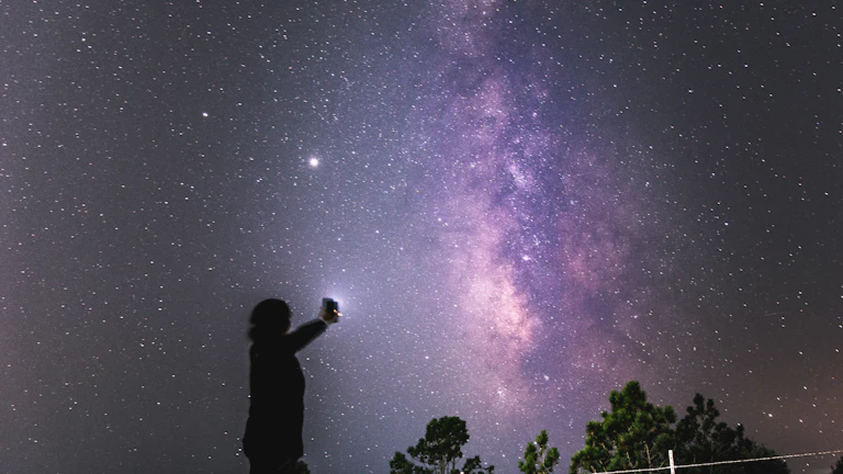 밤하늘의 별을 바라보며 소원을 비는 여성