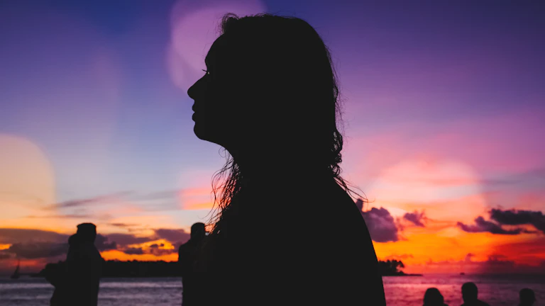 노을을 바라보며 새로운 다짐을 하는 여성